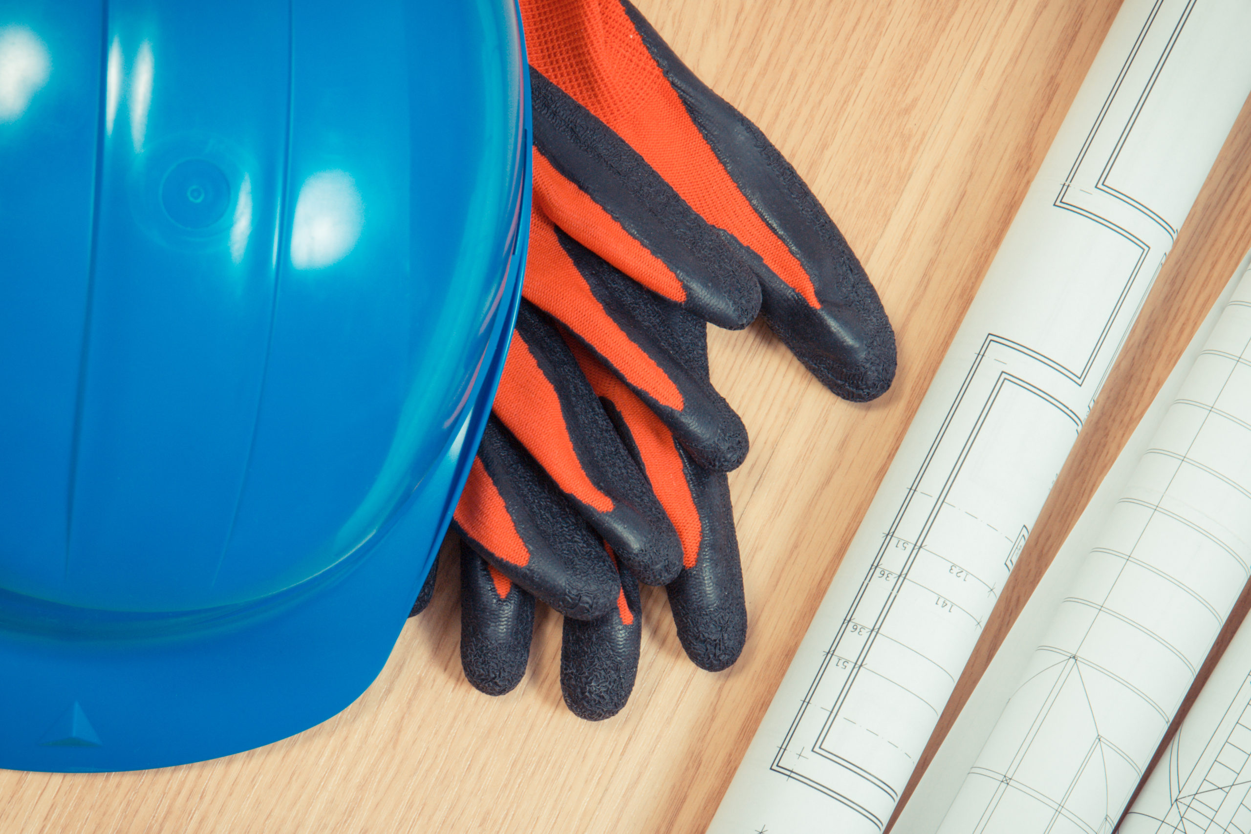 Rolls of diagrams and electrical construction drawings, protective blue helmet and gloves